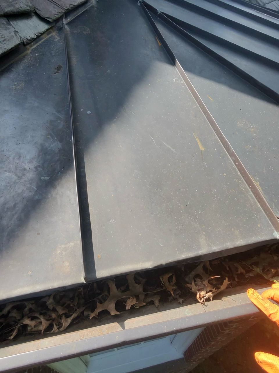 Leaves and packed material in a gutter before Rockland Housewashing clears it.
